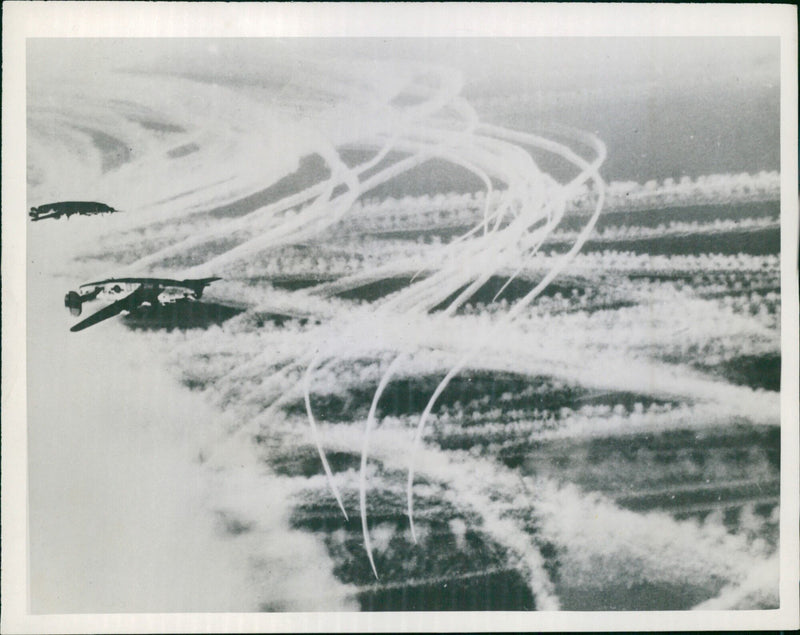 On March 17, 1945, US B-17 Flying Fortresses of the Eighth US Air Force leave contrails in the sky as they speed towards Germany to strike Nazi supply lines and communications. - Vintage Photograph