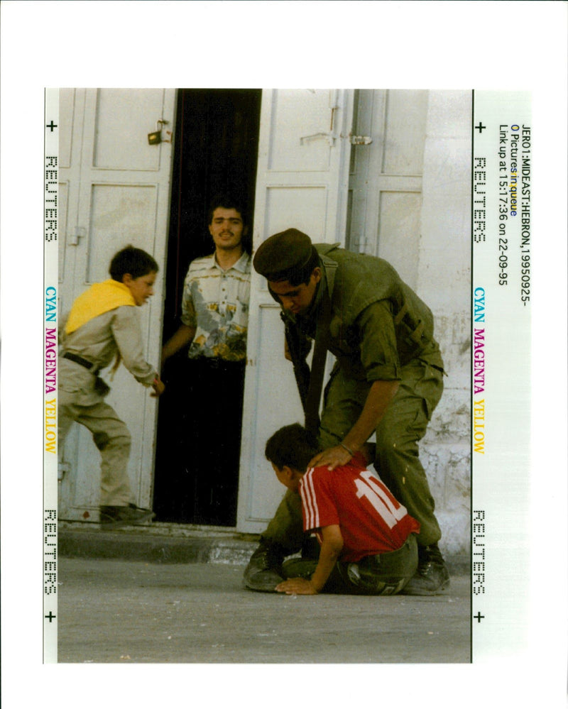 West Bank (Hebron):A young Palestinian boy is grabbed by  an armed Israeli soldier. - Vintage Photograph