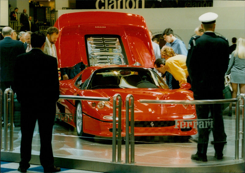 Car enthusiasts admire a Ferrari at the Motor Show in Birmingham, England. - Vintage Photograph