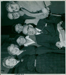 A woman stands in a green meadow with a rainbow and a cloudy sky in the background. - Vintage Photograph