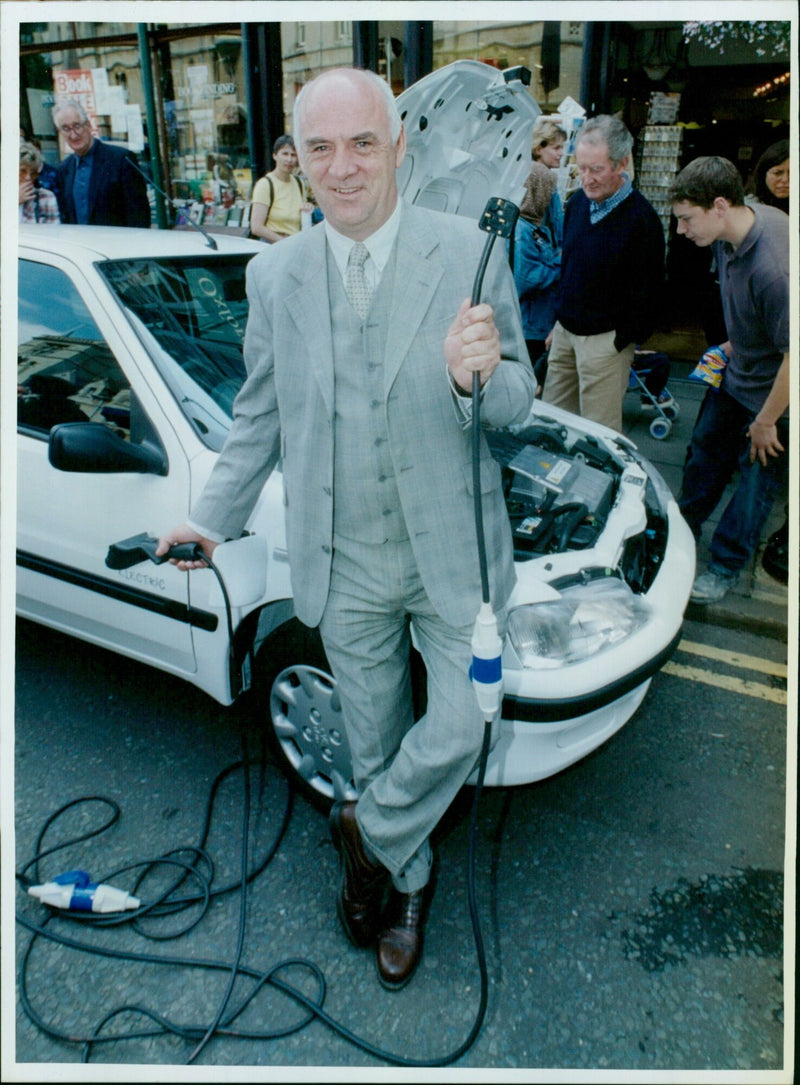 Pat McGivern of Peugeot showcases an electric vehicle at the Oxford Exhibition of clean electric vehicles. - Vintage Photograph