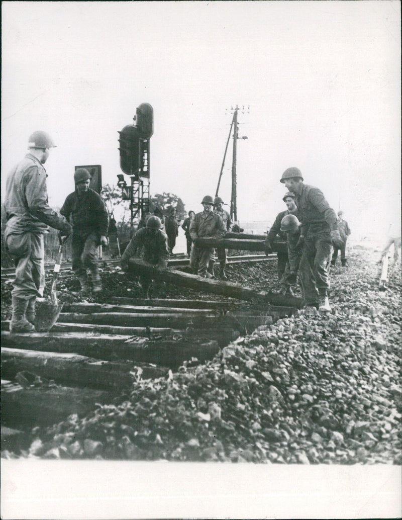 U.S. troops repair a destroyed railroad in France during WWII, as part of a massive effort to supply the Allied fronts. - Vintage Photograph