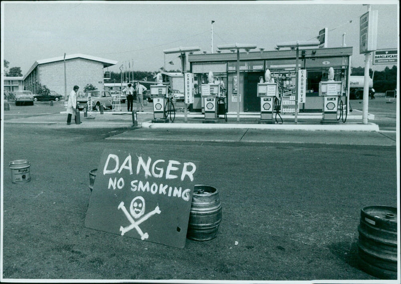 Fire brigade and county petroleum officer attend an Oxford garage yesterday as 6,000 gallons of petrol are removed from an underground tank after a delivery error. - Vintage Photograph