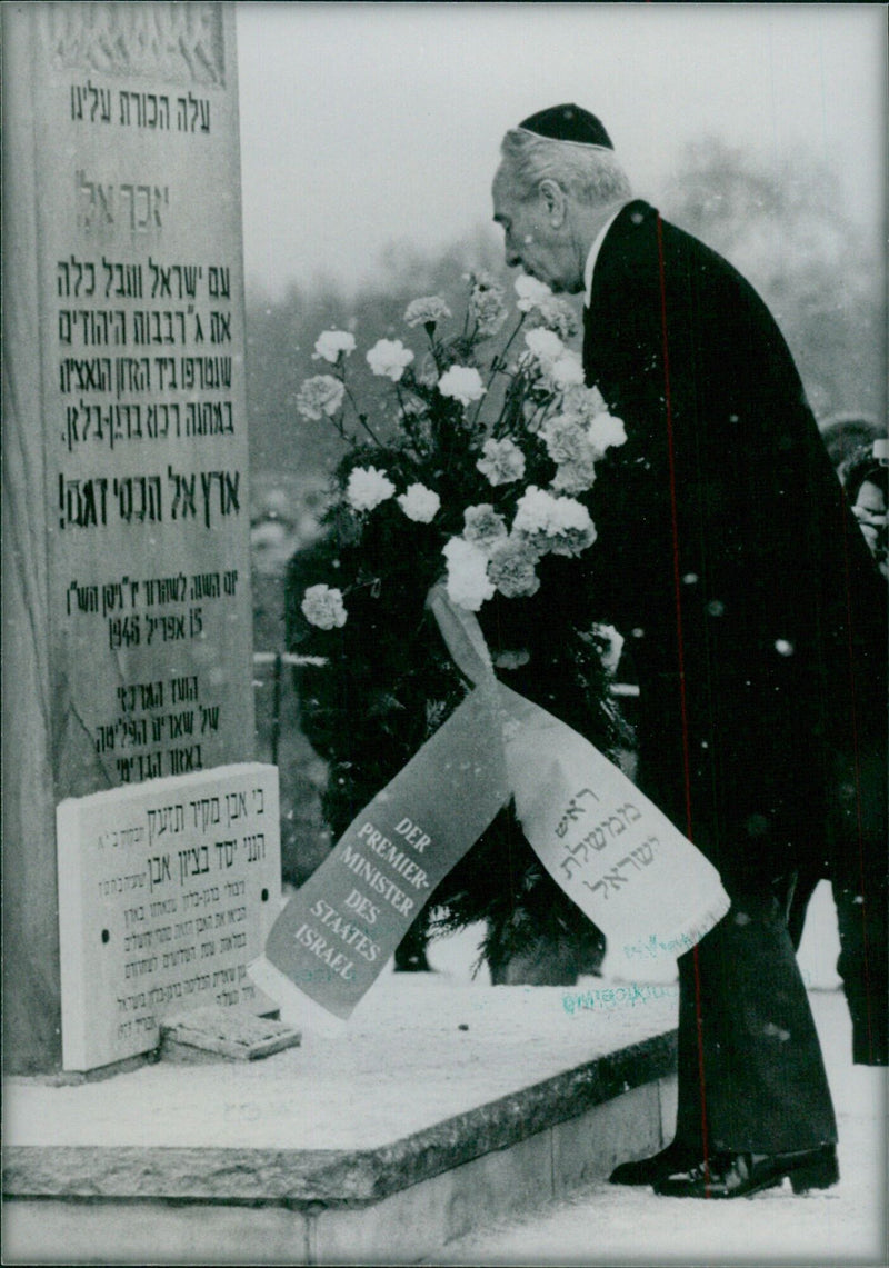 Israeli Prime Minister Shimon Peres lays a wreath at the Jewish memorial in Belsen concentration camp during a visit in January 1986. - Vintage Photograph