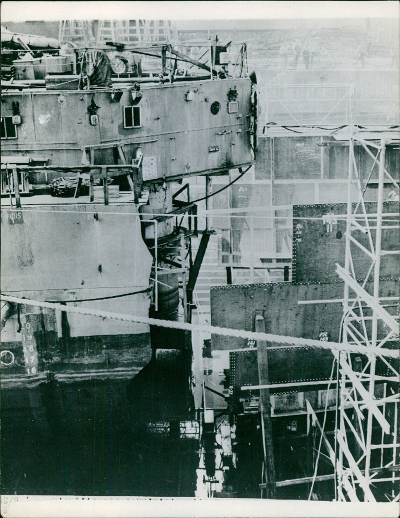 A miracle of fabrication has enabled the USS Angonaut to be fitted with a new stern after being torpedoed by a Nazi U-boat in the Philadelphia Navy Yard, allowing it to return to action against the Japanese in the Pacific. - Vintage Photograph