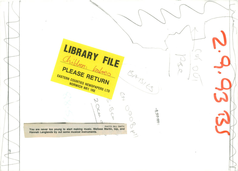 Melissa Martin, top, and Hannah Langlands try out some musical instruments. - Vintage Photograph