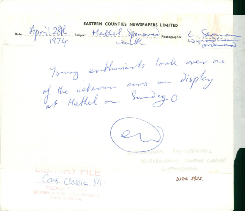 Young enthusials look over one of the veteran cars. - Vintage Photograph