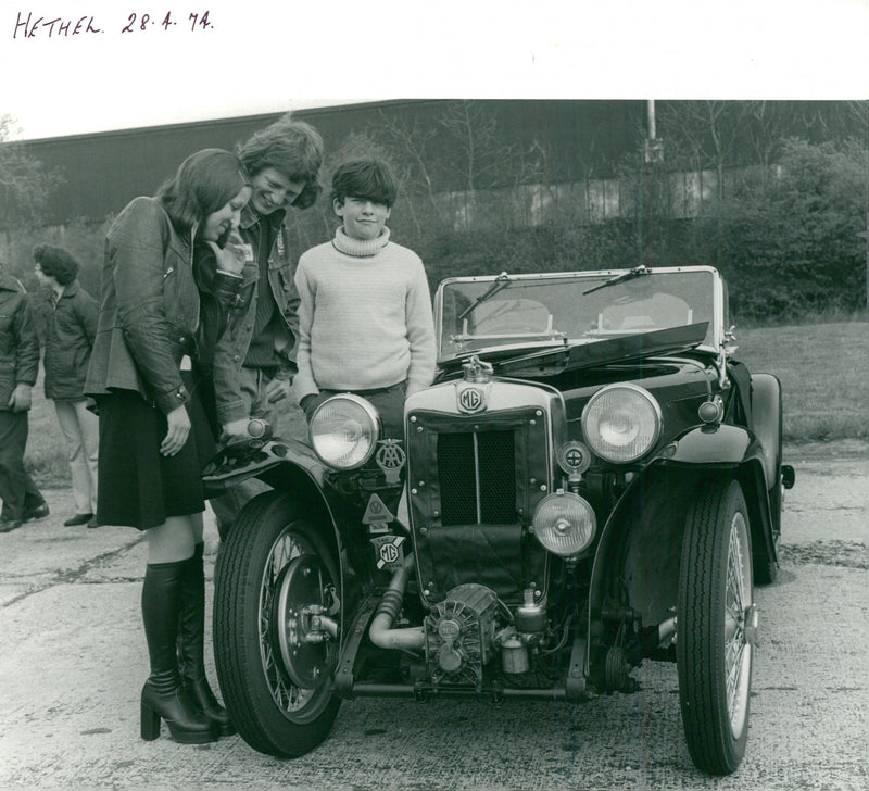 Young enthusials look over one of the veteran cars. - Vintage Photograph