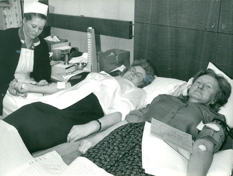 Kathleen White and her sister, Janet Smith donate some of their extremely rare blood which is to be flowm out to West Germany. - Vintage Photograph