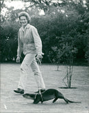 Mrs. Patricia Wayre takes a stroll with her pet Indian otter, Oscar - Vintage Photograph