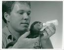 A man feeding animals. - Vintage Photograph