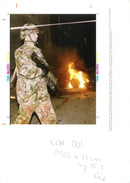 A British soldier walks past the aftermath - Vintage Photograph