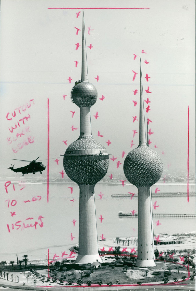 A Royal Navy helicopter flies past the Kuwait Towers. - Vintage Photograph