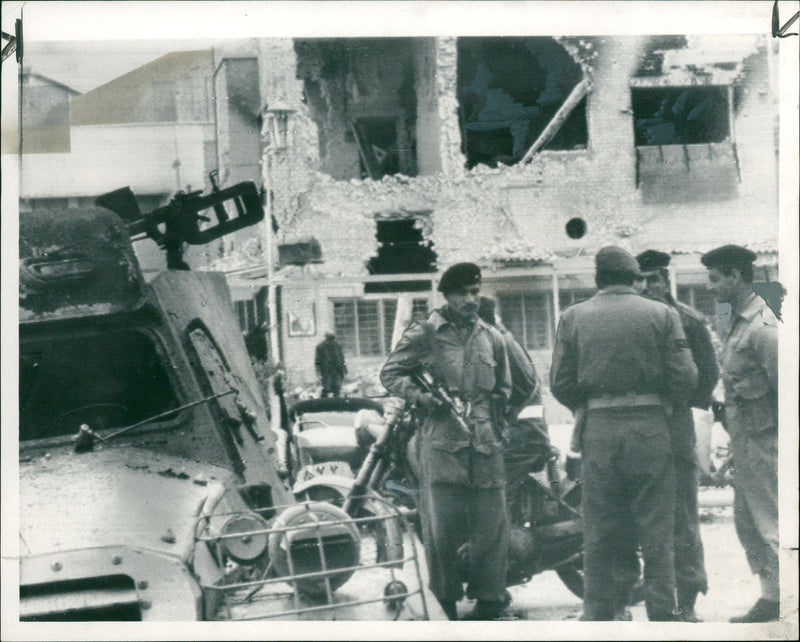 Army officers stand outside the bombed Ministry of Defense building. - Vintage Photograph