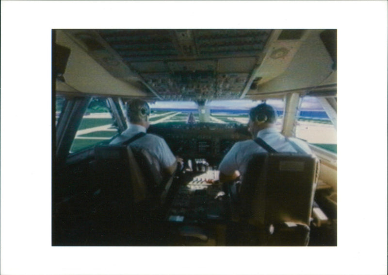 A photo showing two men in an airplane. - Vintage Photograph