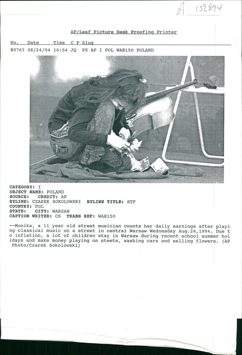 a 11 year old street musician counts her daily earnings after playing [classical muscic on a street. - Vintage Photograph