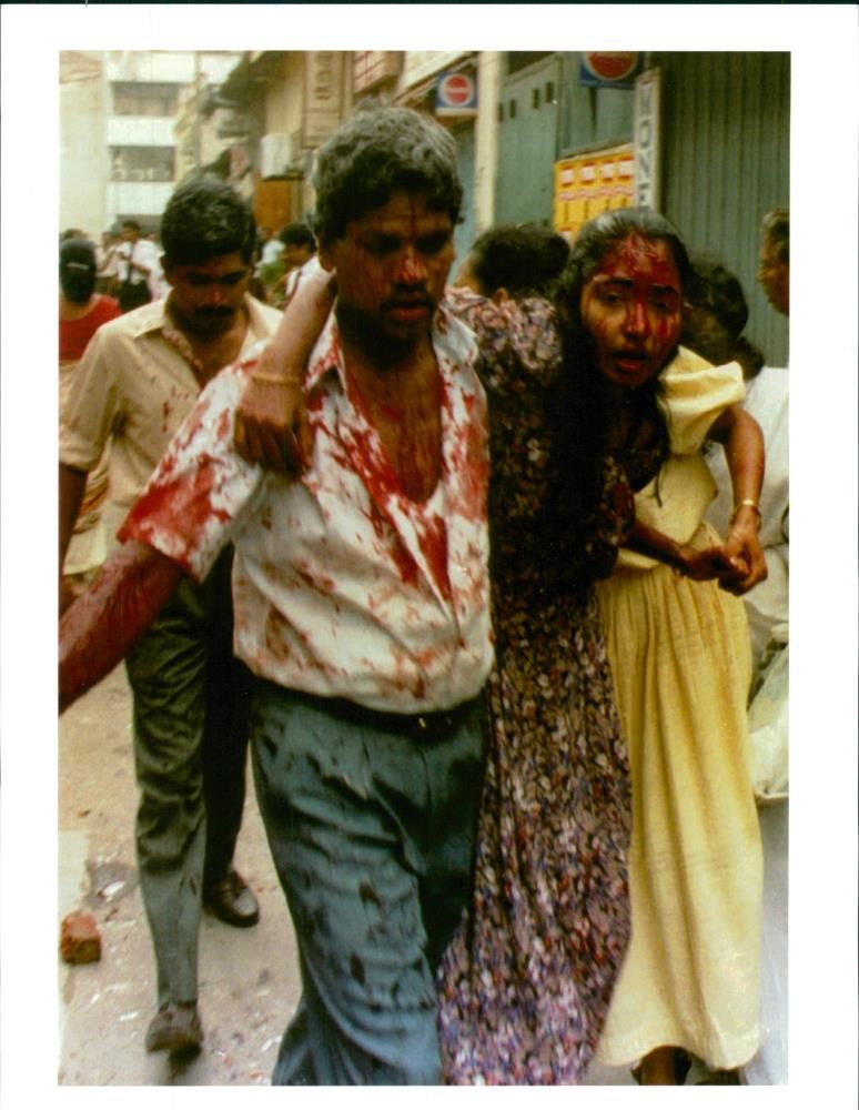 A bloodied couple flees the scene of the bomb blast in Colombo city. - Vintage Photograph