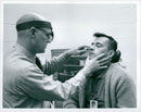 Dr. L. Ballenberger examines astronaut John W. Young - Vintage Photograph