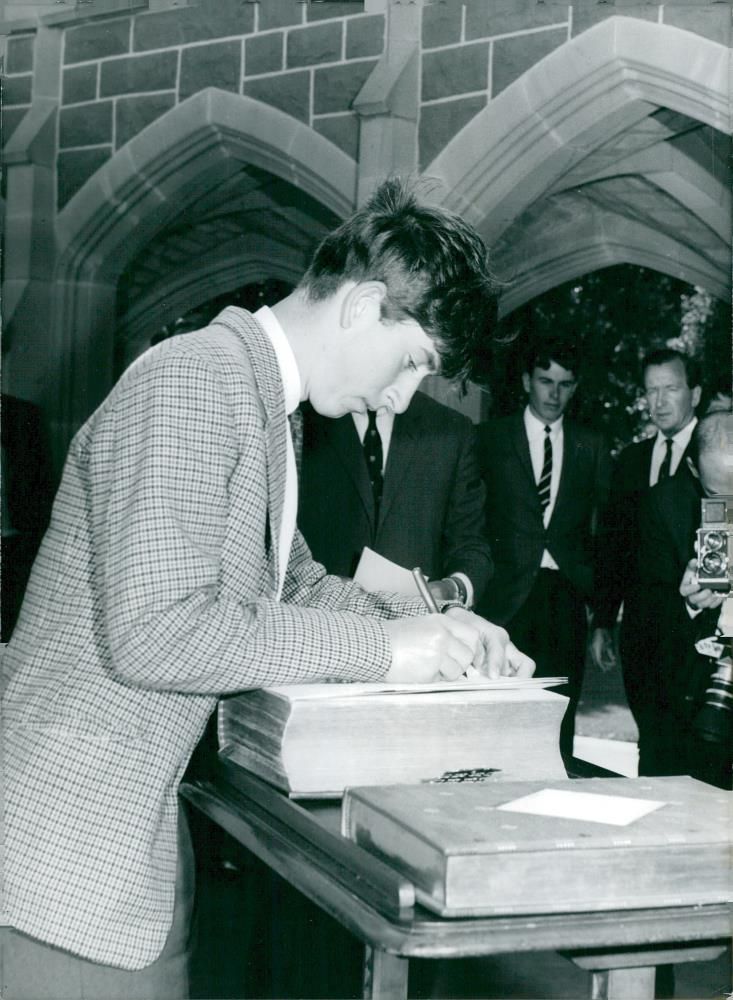 Prince Charles of Wales signs bible by visiting the Geelong Grammar School. - Vintage Photograph