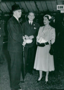 King Gustaf VI Adolf talks with Queen Elizabeth at the big flower show in Chelsea. - Vintage Photograph