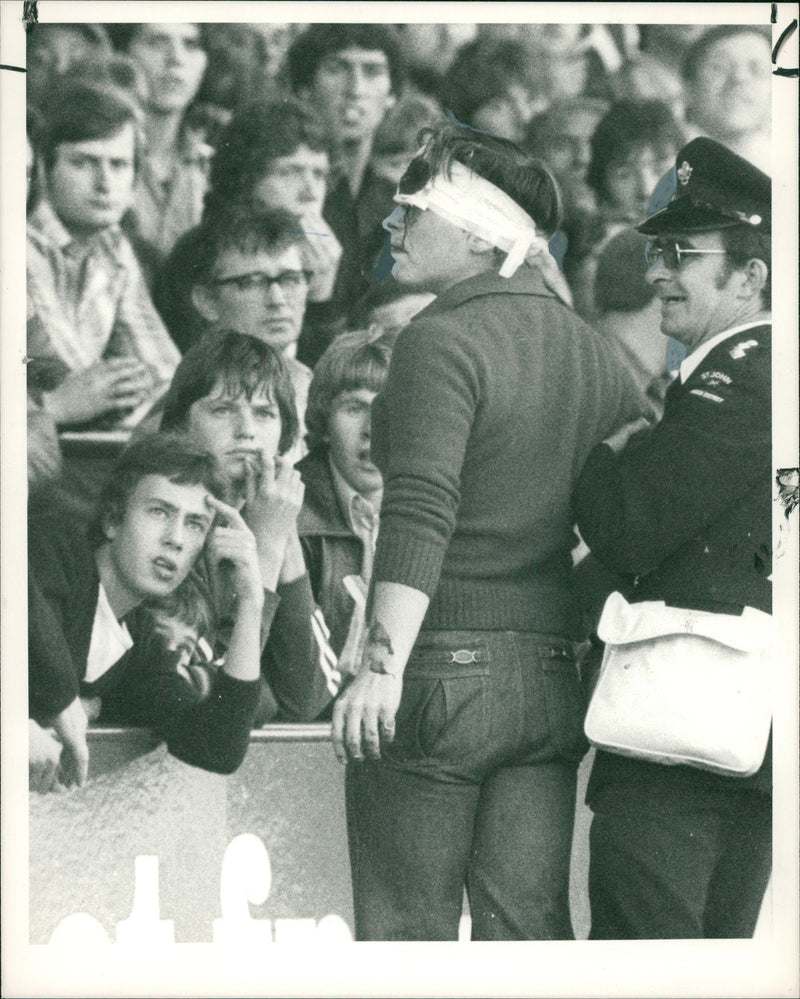 A blood stained fan being led away. - Vintage Photograph