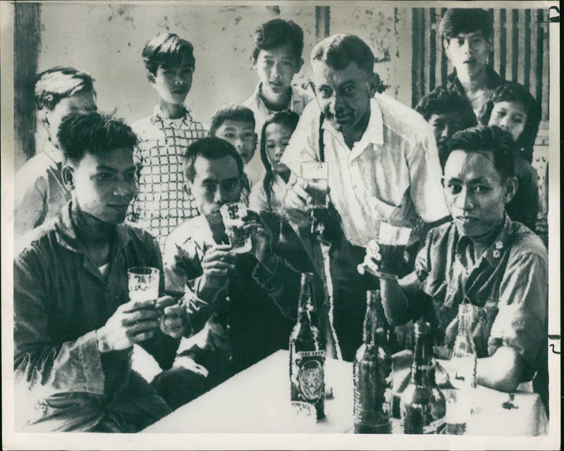 A photographer joining in a toast with Viet Cong and South Vietnamese soldiers during Vietnam War - Vintage Photograph