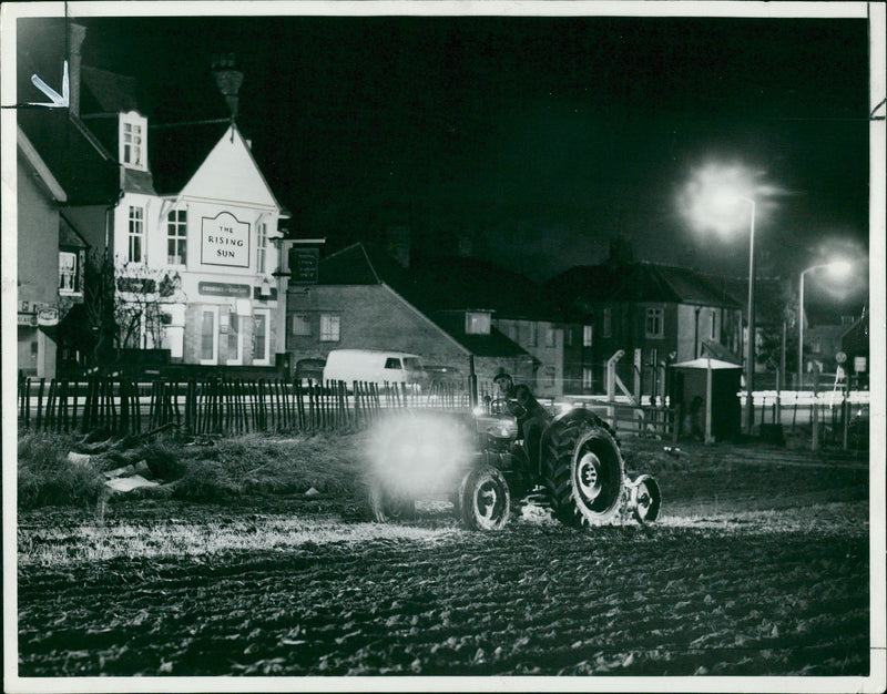 Aid of street lamps and headlights on his tractor. - Vintage Photograph