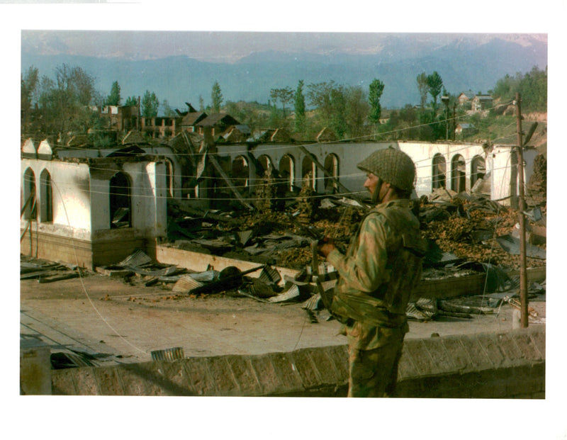 An Indian soldier guards the burnt out Muslim shrine - Vintage Photograph