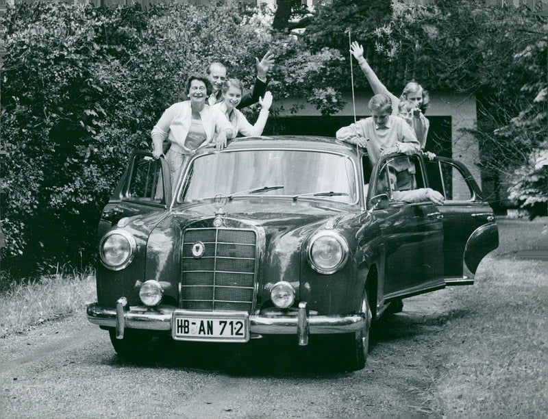 Family idyll: Prince Louis Ferdinand of Preussen with his wife Kyra and the children kiss and wave standing in his Mercedes Benz 22 0S - Vintage Photograph