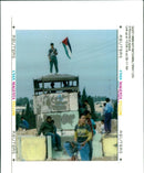 A palestinian with a palestinian flag a top the israeli army roadblock tower. - Vintage Photograph