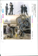 The Rwandan War:Two Rwandan refugees carry away jerry cans filled with clean water. - Vintage Photograph