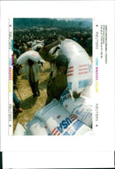 Rwanda war:rwandan refugees puts a sack of maize. - Vintage Photograph