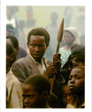 A militia Rwandan holding a spear at a refugee camp. - Vintage Photograph