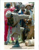 A Rwanda Governmental soldier kicks behind him. - Vintage Photograph