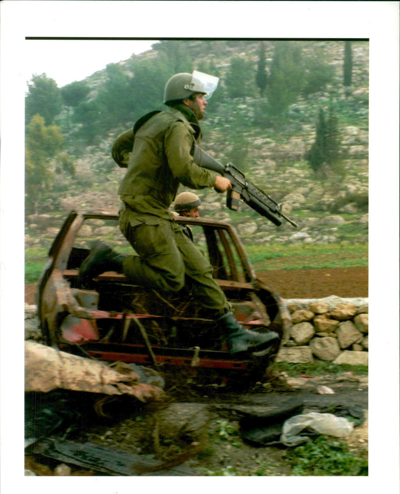 West Bank:An Israeli soldier hurdles a barricade. - Vintage Photograph