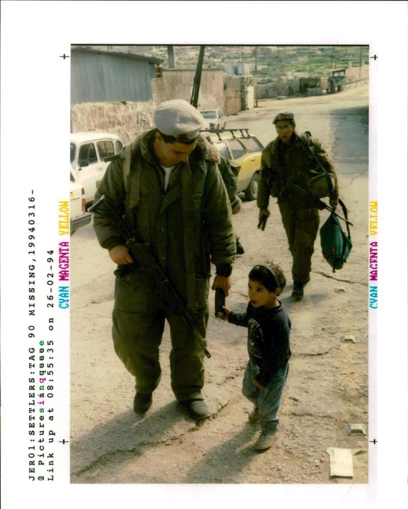 West Bank (Hebron):A young settler boy holds on to an  Israeli  soldier. - Vintage Photograph