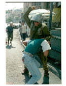 West Bank (Hebron):An Israeli soldier strikes a Palestinian youth. - Vintage Photograph