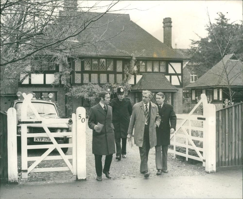 Ross McWhirter,Det Chief SPT Nigel Reid light raincoat leaving the McWhirter home in Village Road Enfield Today. - Vintage Photograph