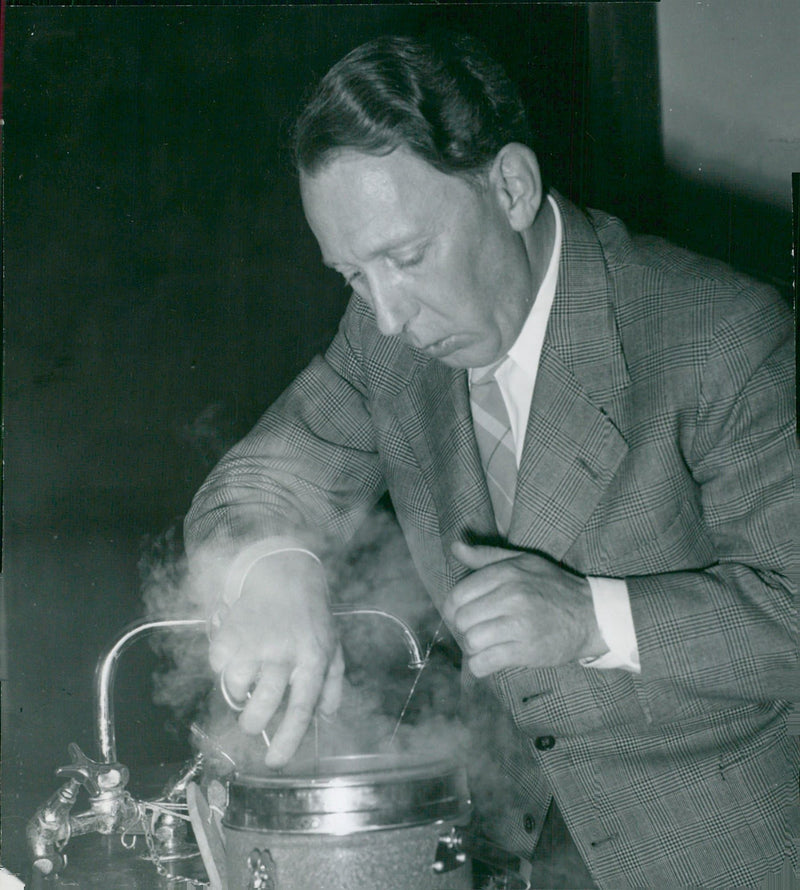 Dr Allan Bane takes a ampoule of bulb sperm from a thermos at the Animal Husbandry Center in Ultuna - Vintage Photograph