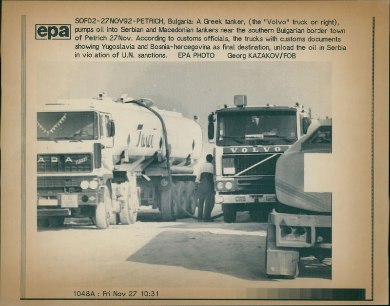 A greek tanker the Volvo truck on right pumps oil into serbian and macedonian tankers. - Vintage Photograph