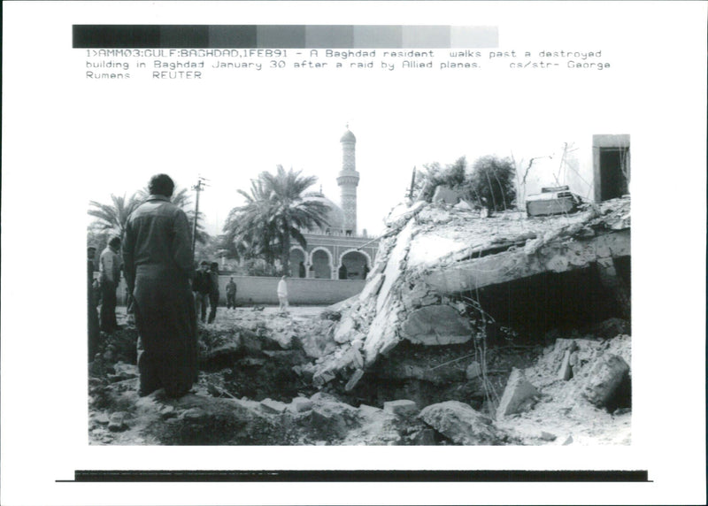 A baghdad resident walks past a destroyed building. - Vintage Photograph