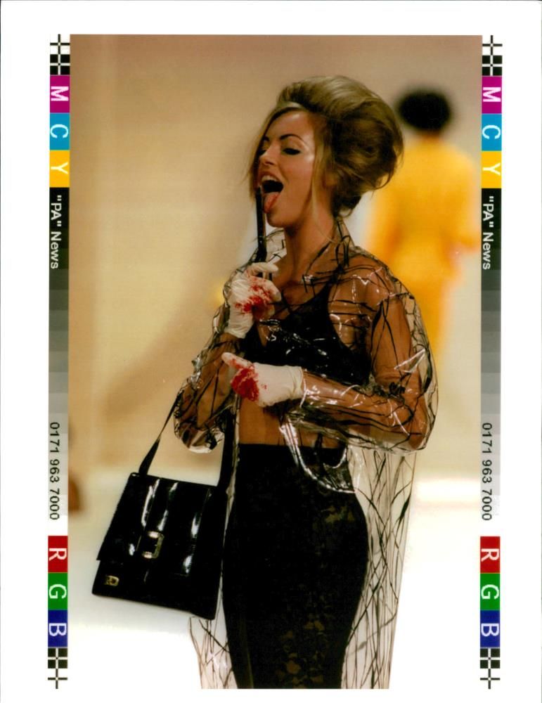 Fashion:A model licks a pair of blood stained. - Vintage Photograph