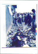 1991 uprisings in Iraq: A man throwing a stone to two person with bloody faces. - Vintage Photograph