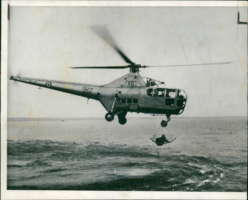 Aircraft helicopter rescue:royal navy rescue device a man being rescue. - Vintage Photograph