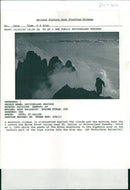 A mountain climber is silhouetted against the clouds. - Vintage Photograph