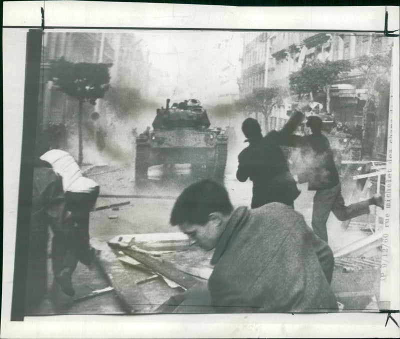 Algeria Riots:a tank bearing down stone throwing rioter in algiers yesterday. - Vintage Photograph