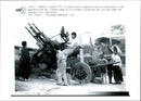 Iraq -un war kuwait city war damage:a kuwaiti family inspects an anti-aircraft position on the beachfront. - Vintage Photograph