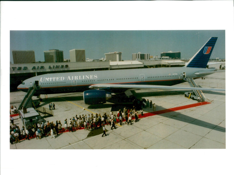 United airlines employees gather around a Boeing 777. - Vintage Photograph