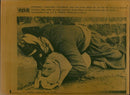Shows a dead man holding a baby. - Vintage Photograph
