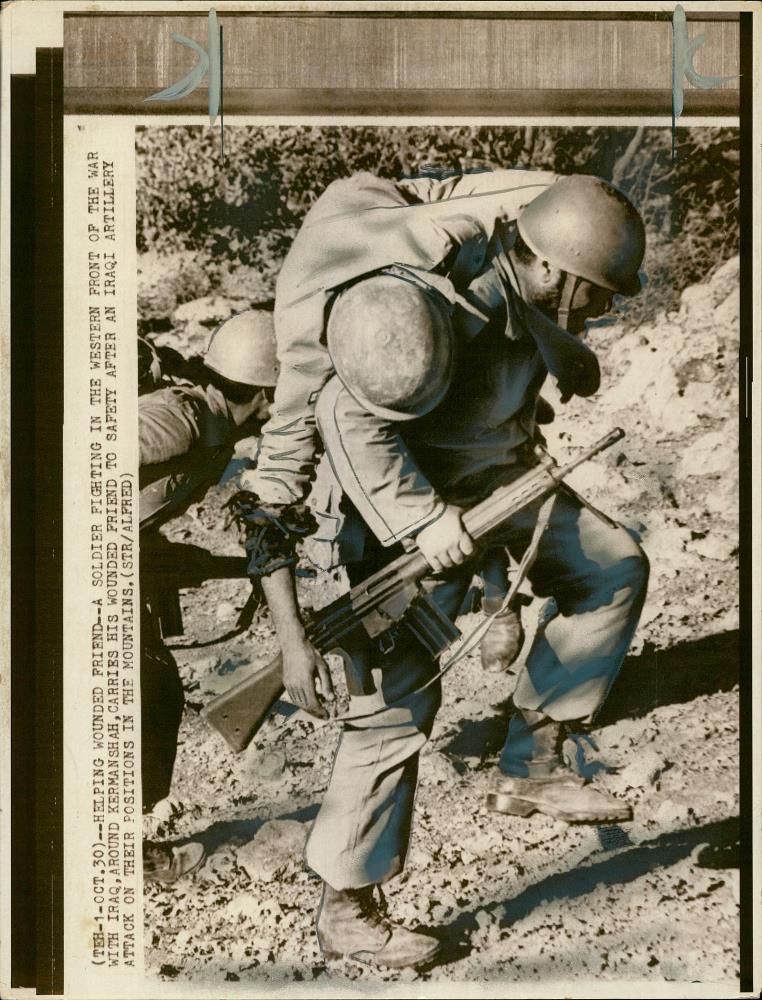 A iranian soldiers being carried away. - Vintage Photograph